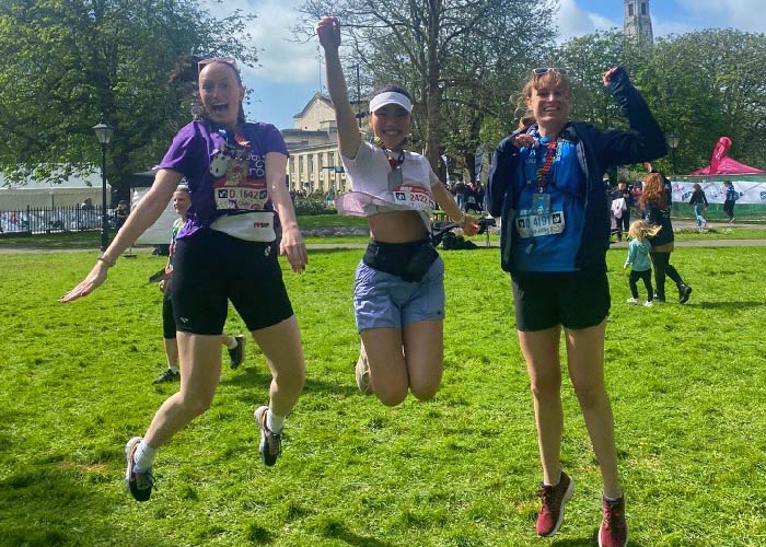 Chelsea, Yilin, and An-Sofie jumping in the air in a celebratory pose after running in the Southampton marathon